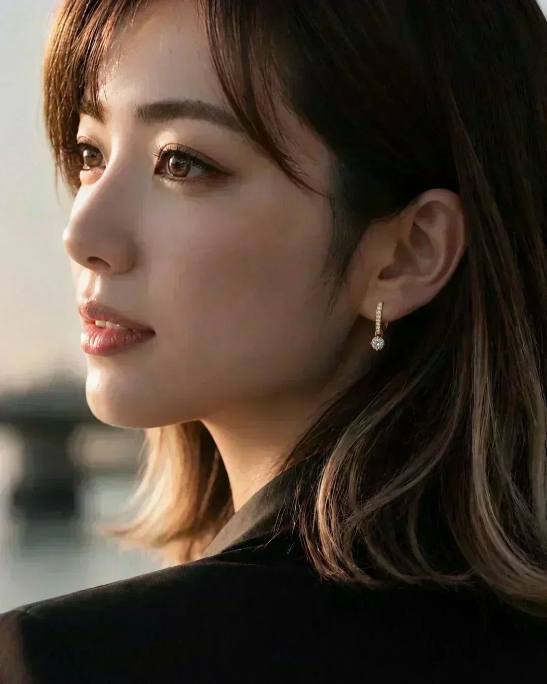 Model wearing 18K gold diamond drop earrings with a small round lab-grown diamond pendant.