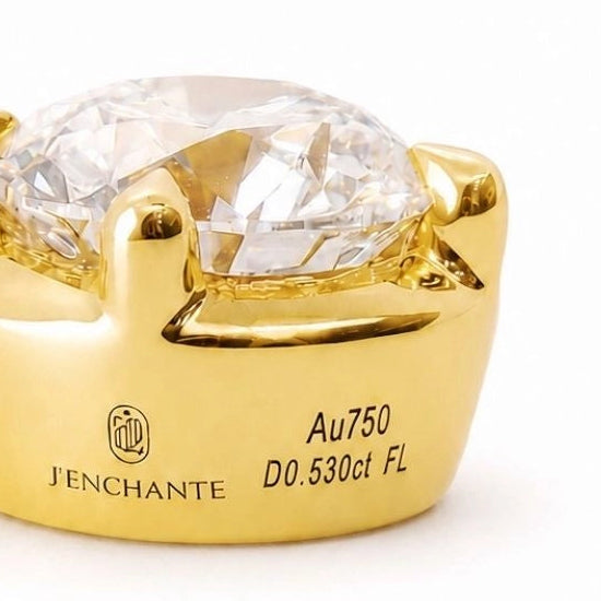 Close-up of a J'ENCHANTE 18K gold diamond setting with Au750 hallmark and engraved brand details, showing fine-jewelry craftsmanship and secure diamond support.