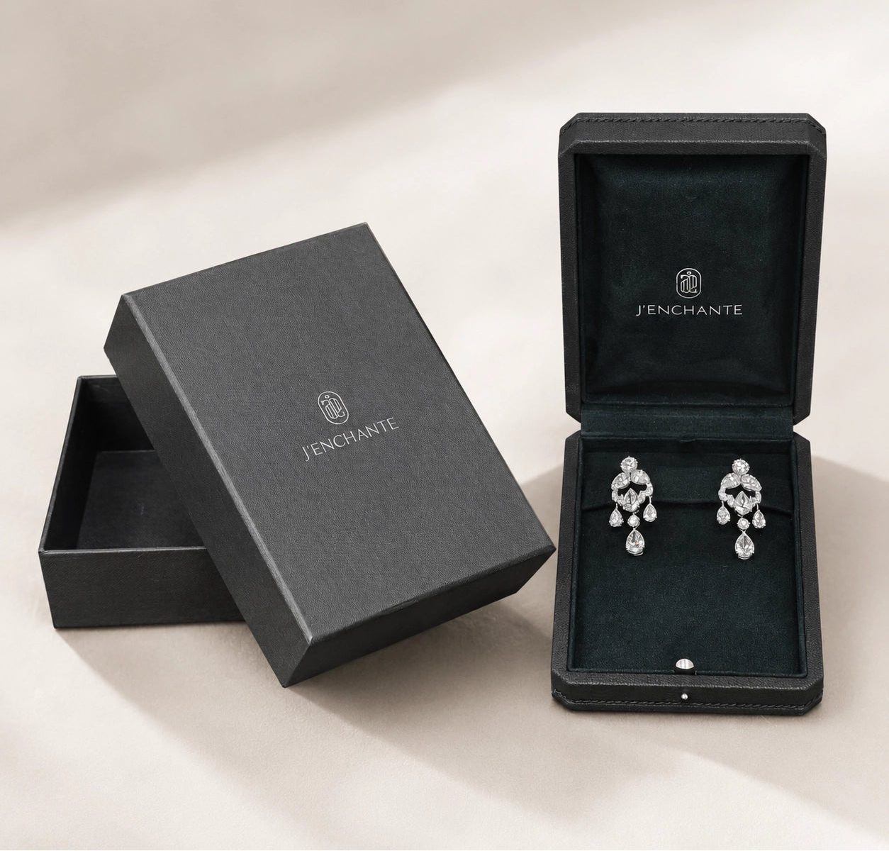 Diamond earrings displayed inside a J'ENCHANTE jewelry box with branded packaging, representing safe storage after cleaning.