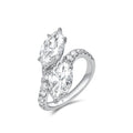 Angled view of the J'ENCHANTE DUO marquise diamond bypass ring. The perspective highlights the sculptural 18K white gold setting and the flowing lines of the pavé-set band. The elevated 2-carat marquise diamonds catch the light brilliantly, emphasizing the ring's striking depth and dynamic movement.
