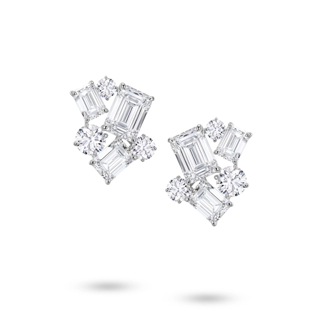 Front view of the J'ENCHANTE The Facette Structure diamond earrings in 18K white gold. Showcasing a bold architectural cluster, each earring is anchored by a 2.0-carat emerald-cut center diamond, surrounded by offset emerald and round brilliant stones (12 diamonds totaling approx. 9.37 carats). This precise geometric composition creates a refined interplay of light, shadow, and striking linear elegance.