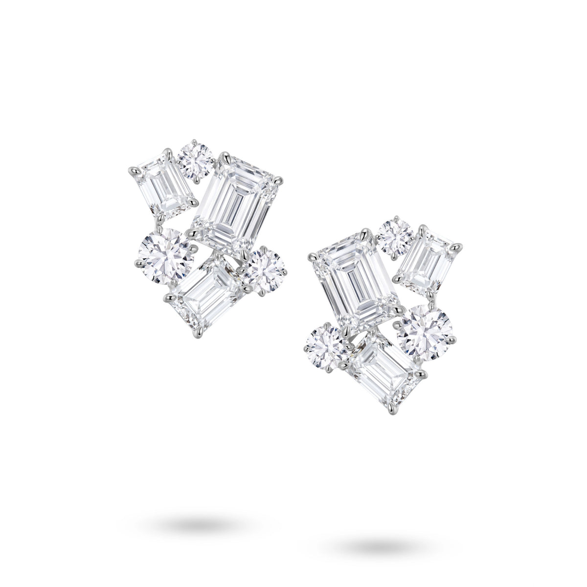 Front view of the J'ENCHANTE The Facette Structure diamond earrings in 18K white gold. Showcasing a bold architectural cluster, each earring is anchored by a 2.0-carat emerald-cut center diamond, surrounded by offset emerald and round brilliant stones (12 diamonds totaling approx. 9.37 carats). This precise geometric composition creates a refined interplay of light, shadow, and striking linear elegance.