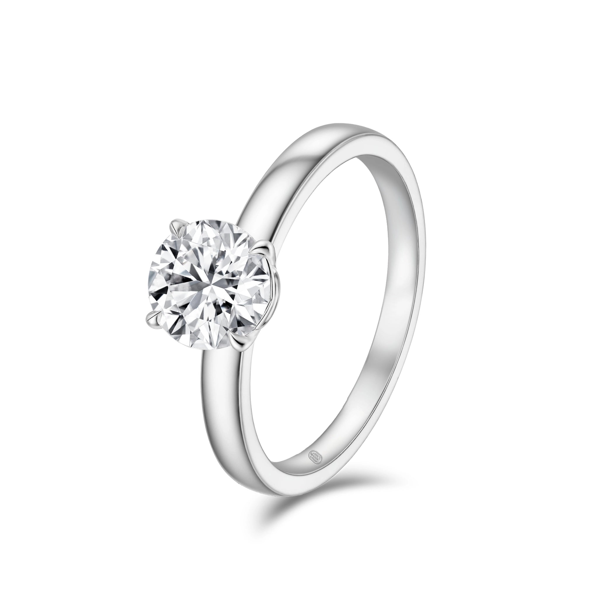 Angled view of the J'ENCHANTE JOY 18k white gold classic solitaire ring, showcasing the fluid lines of the band and the unique architectural details of the signature J-Setting.