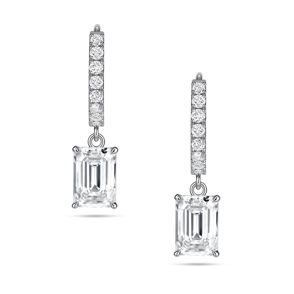 Front view of the J'ENCHANTE JOY emerald drop earrings, featuring a pair of refined 18K white gold hoops adorned with 16 pavé-set diamonds (approx. 0.2 carats). The clean linear hoops create a sophisticated contrast with the clear, architectural silhouette of the suspended emerald-cut focal stones.