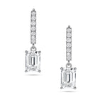 Front view of the J'ENCHANTE JOY emerald drop earrings, featuring a pair of refined 18K white gold hoops adorned with 16 pavé-set diamonds (approx. 0.2 carats). The clean linear hoops create a sophisticated contrast with the clear, architectural silhouette of the suspended emerald-cut focal stones.