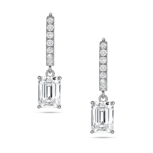 Front view of the J'ENCHANTE JOY emerald drop earrings, featuring a pair of refined 18K white gold hoops adorned with 16 pavé-set diamonds (approx. 0.2 carats). The clean linear hoops create a sophisticated contrast with the clear, architectural silhouette of the suspended emerald-cut focal stones.