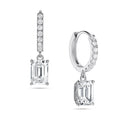 Angled view of the J'ENCHANTE JOY emerald drop earrings in 18K white gold. The image showcases a pair of slim pavé hoops and architectural emerald-cut drops, highlighting the signature J-shaped side profile designed to maximize light passing through for enhanced step-cut clarity.