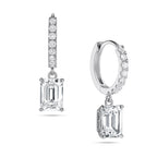 Angled view of the J'ENCHANTE JOY emerald drop earrings in 18K white gold. The image showcases a pair of slim pavé hoops and architectural emerald-cut drops, highlighting the signature J-shaped side profile designed to maximize light passing through for enhanced step-cut clarity.