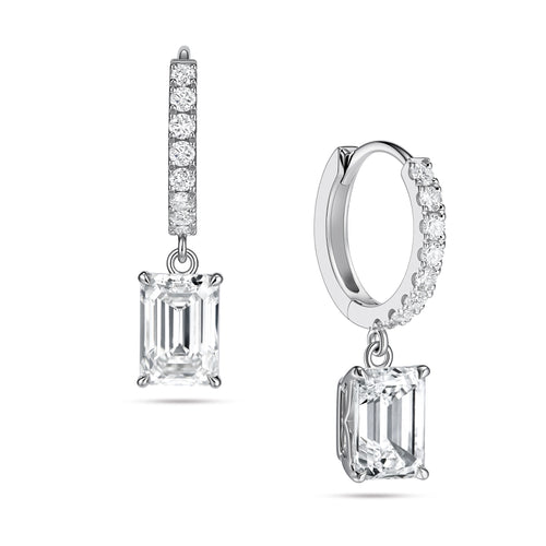 Angled view of the J'ENCHANTE JOY emerald drop earrings in 18K white gold. The image showcases a pair of slim pavé hoops and architectural emerald-cut drops, highlighting the signature J-shaped side profile designed to maximize light passing through for enhanced step-cut clarity.