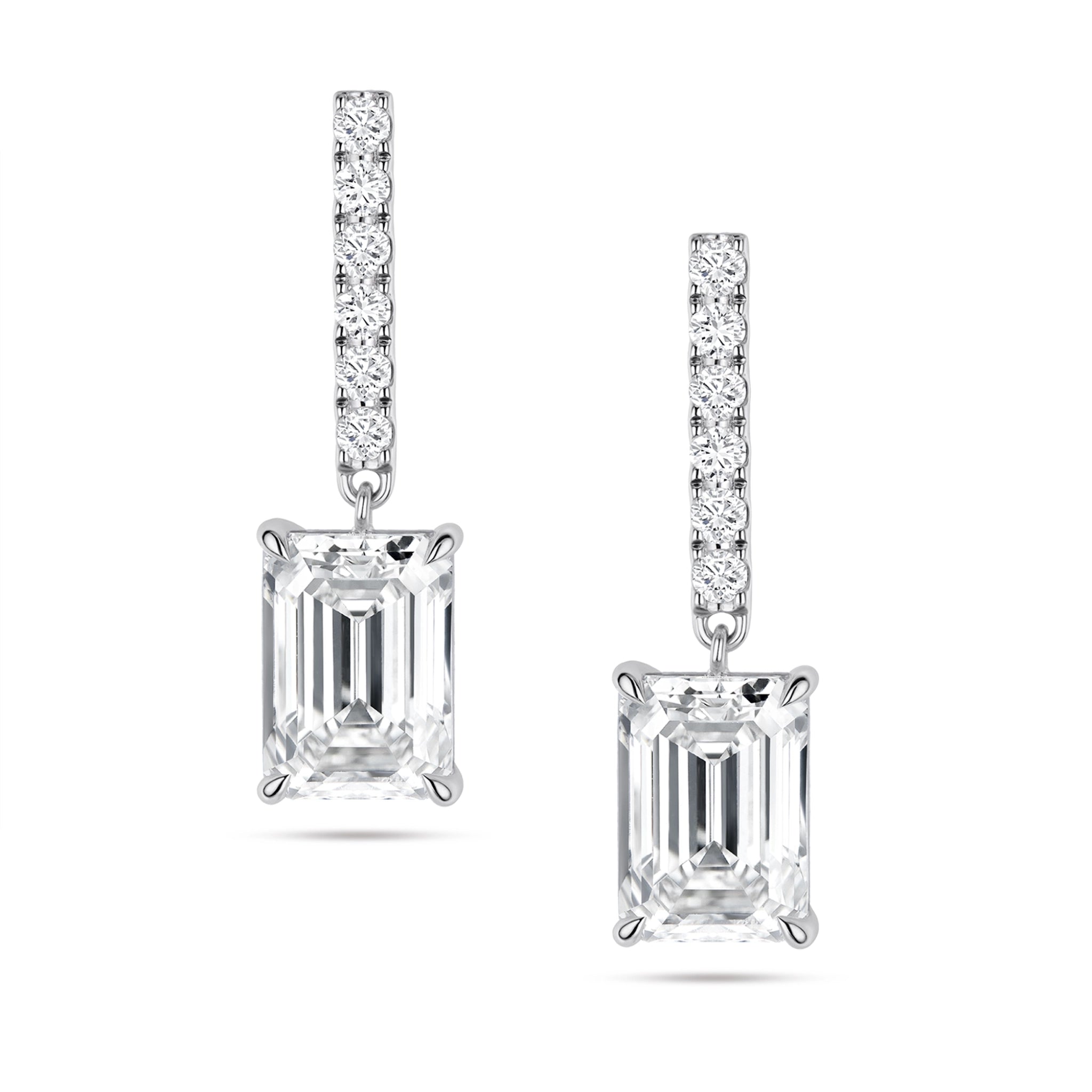 Front view of the J'ENCHANTE JOY emerald bar stud earrings, featuring slim vertical bars pavé-set with 12 diamonds (approx. 0.2 carats). The clean lines of the pavé bar create a refined, architectural contrast with the distinct step-cut brilliance of the suspended emerald-cut focal stones.