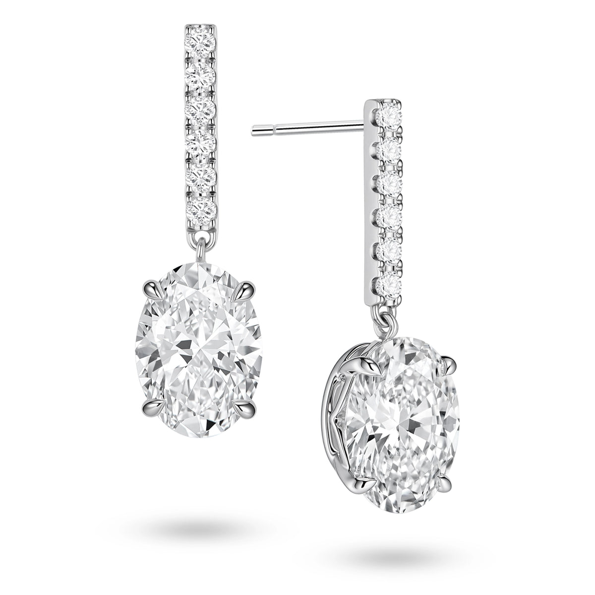 Angled view of the J'ENCHANTE JOY oval bar stud earrings, highlighting the secure stud post and the signature J-shaped side profile of the sculpted setting. This design maximizes side light entry to enhance the clarity and dimension of the oval diamond drop.