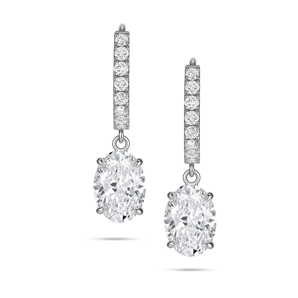 Front view of the J'ENCHANTE JOY oval drop earrings, featuring a pair of refined 18K white gold hoops adorned with 16 pavé-set diamonds (approx. 0.2 carats). The clean linear hoops create a beautiful, graceful contrast with the softly contoured, suspended oval diamond focal stones.