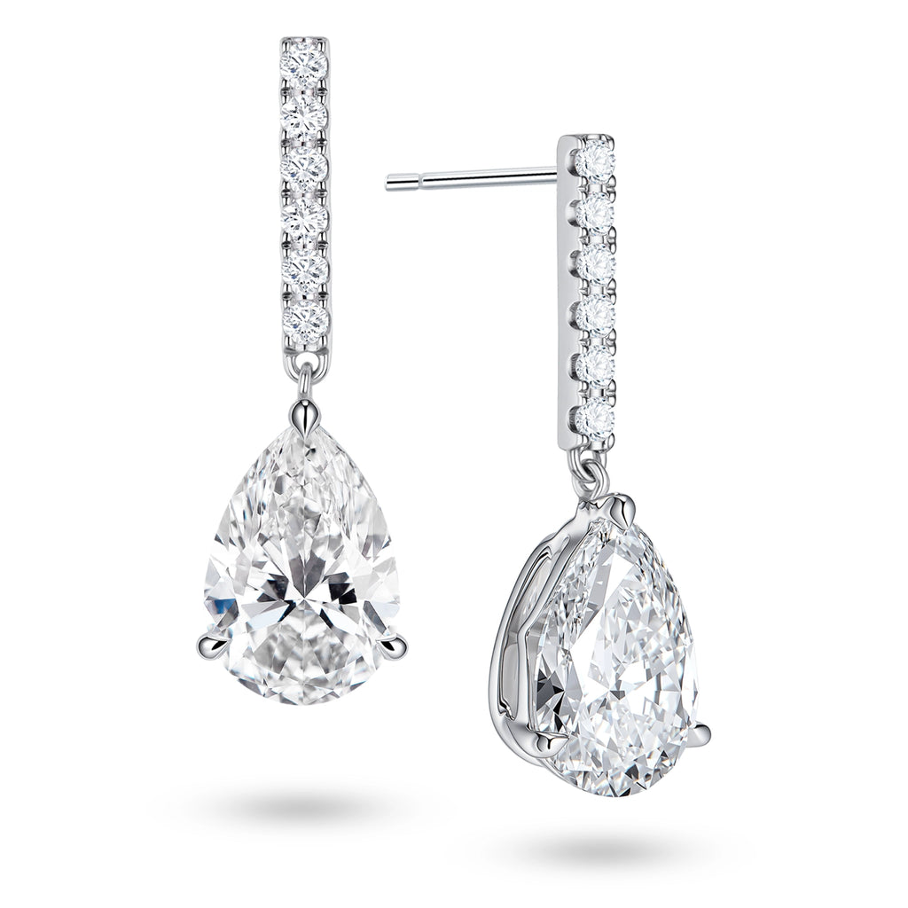 Angled view of the J'ENCHANTE JOY pear bar stud earrings, highlighting the secure stud post and the signature J-shaped side profile of the sculpted setting. This design maximizes side light entry to enhance the clarity and dimension of the pear-shaped drop.