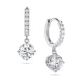 Angled view of the J'ENCHANTE JOY round drop earrings in 18K white gold, showcasing a pair of slim pavé hoops and brilliant round drops. One earring highlights the signature J-shaped side profile, designed to maximize side light entry for enhanced diamond clarity and depth.