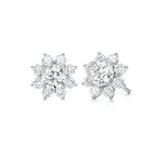 Angled view of the J'ENCHANTE LIFE Bloom diamond stud earrings in white gold. Inspired by a sunflower silhouette, each earring features a luminous center diamond framed by a radiant halo of 16 round stones (approx. 0.88 carats). The refined layered setting amplifies light and dimension, naturally drawing the eye to the brilliant core.