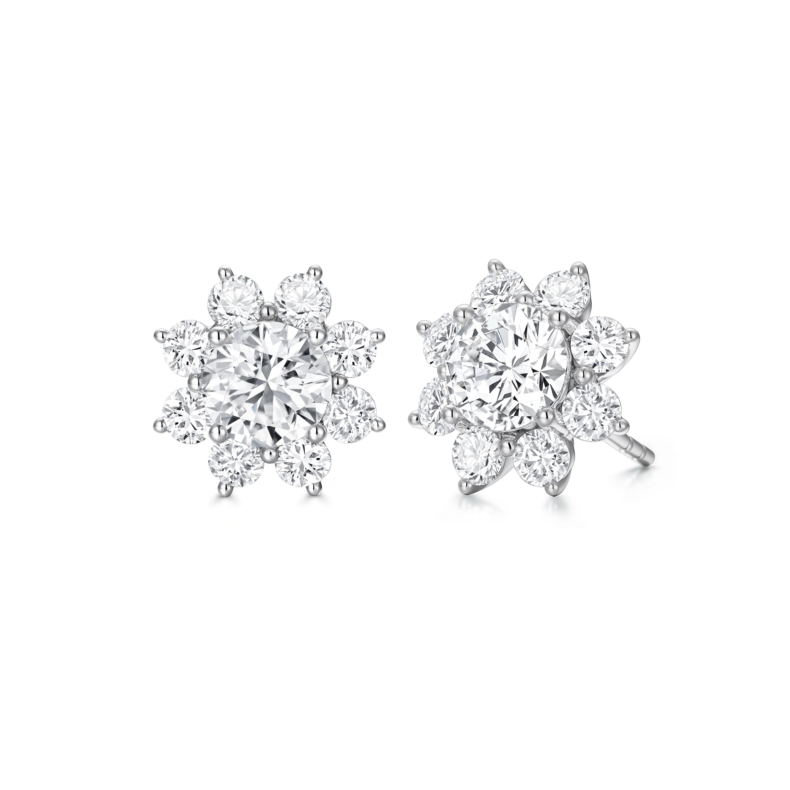 Angled view of the J'ENCHANTE LIFE Bloom diamond stud earrings in white gold. Inspired by a sunflower silhouette, each earring features a luminous center diamond framed by a radiant halo of 16 round stones (approx. 0.88 carats). The refined layered setting amplifies light and dimension, naturally drawing the eye to the brilliant core.
