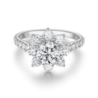 Front view of the J'ENCHANTE LIFE Full Bloom diamond ring in white gold. A commanding 1-carat round center diamond is encircled by a radiant sunflower-inspired halo. Paired with a delicately pavé-set band featuring 22 round diamonds (approx. 1.0 carats), the design creates a stunning, luminous floral silhouette.