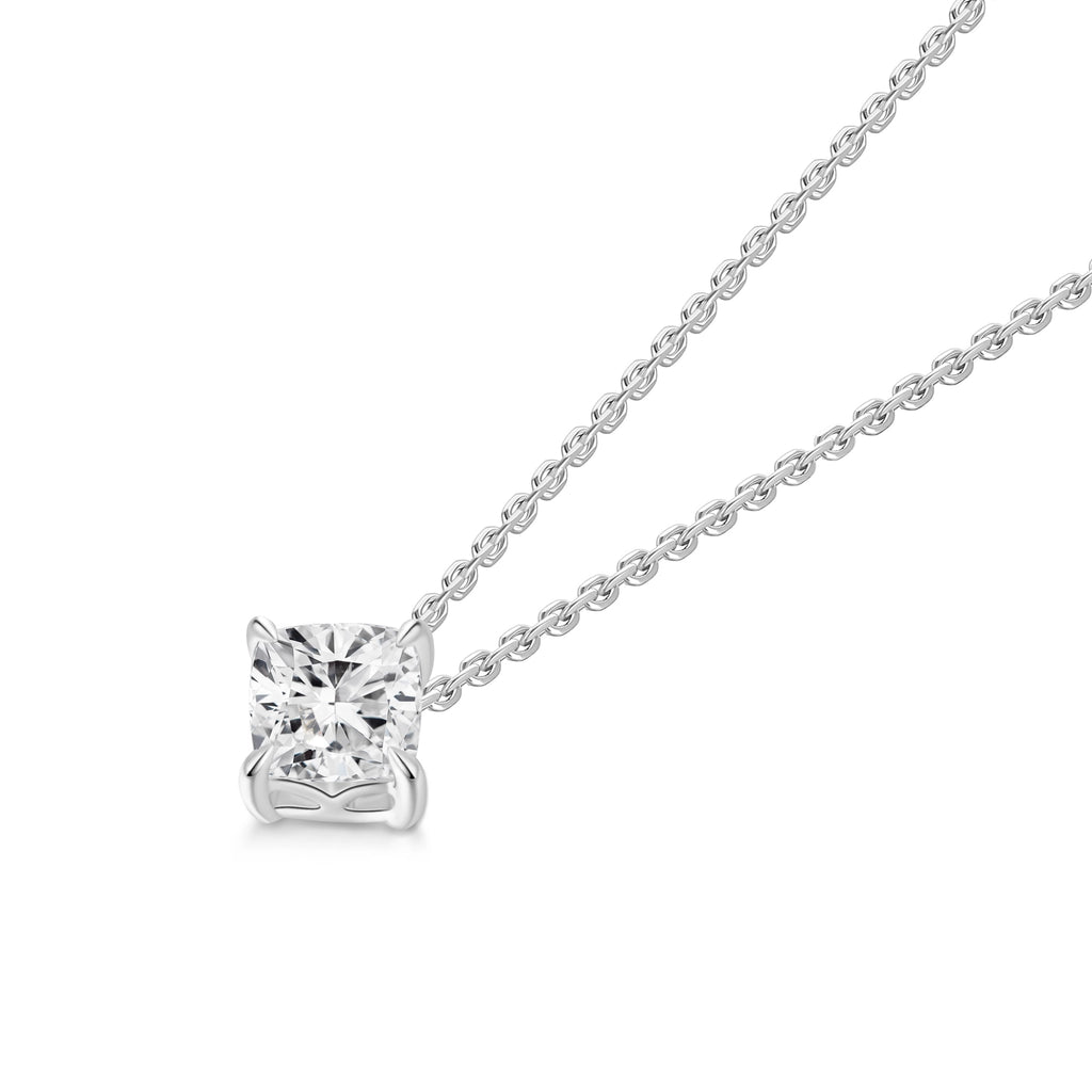 Angled view of the J'ENCHANTE ONE cushion diamond necklace, highlighting the signature J-setting. The elegant architectural curve cradles and elevates the cushion-cut stone, maximizing light return from every facet. A pure expression of form where simplicity becomes a statement.