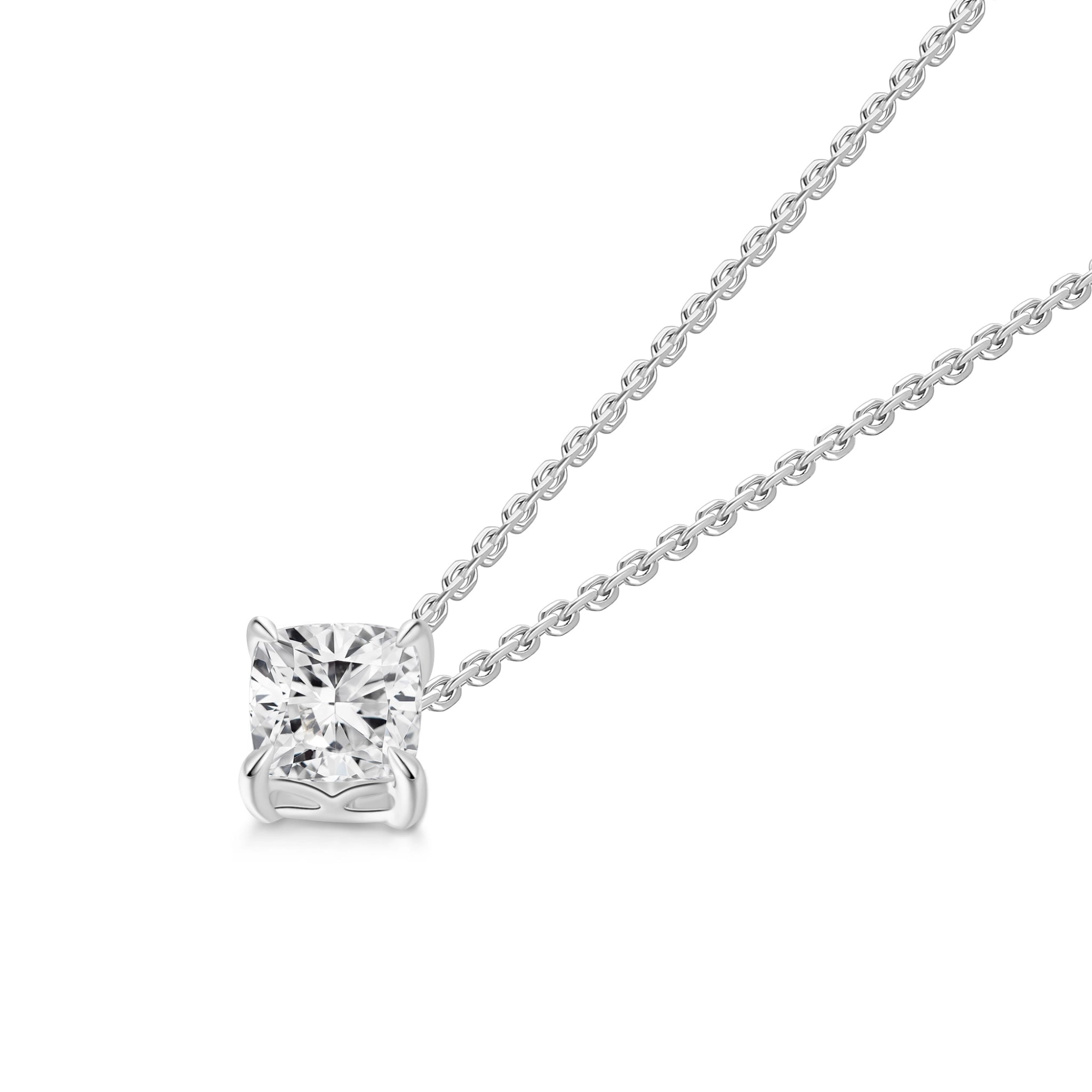 Angled view of the J'ENCHANTE ONE cushion diamond necklace, highlighting the signature J-setting. The elegant architectural curve cradles and elevates the cushion-cut stone, maximizing light return from every facet. A pure expression of form where simplicity becomes a statement.