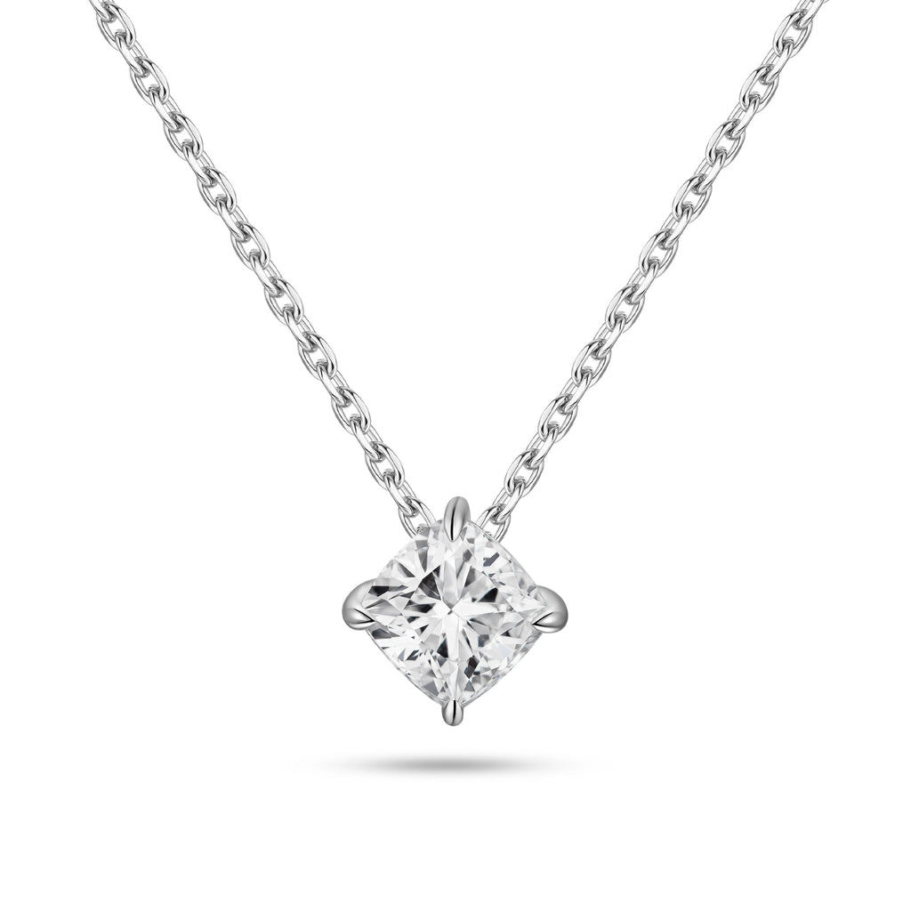 Front view of the J'ENCHANTE ONE cushion-cut diamond solitaire necklace. Suspended on a white gold chain, the brilliant cushion diamond is uniquely kite-set (compass set) to create a striking geometric silhouette. The refined single-stone design allows light to flow naturally, emitting a quiet yet confident brilliance.
