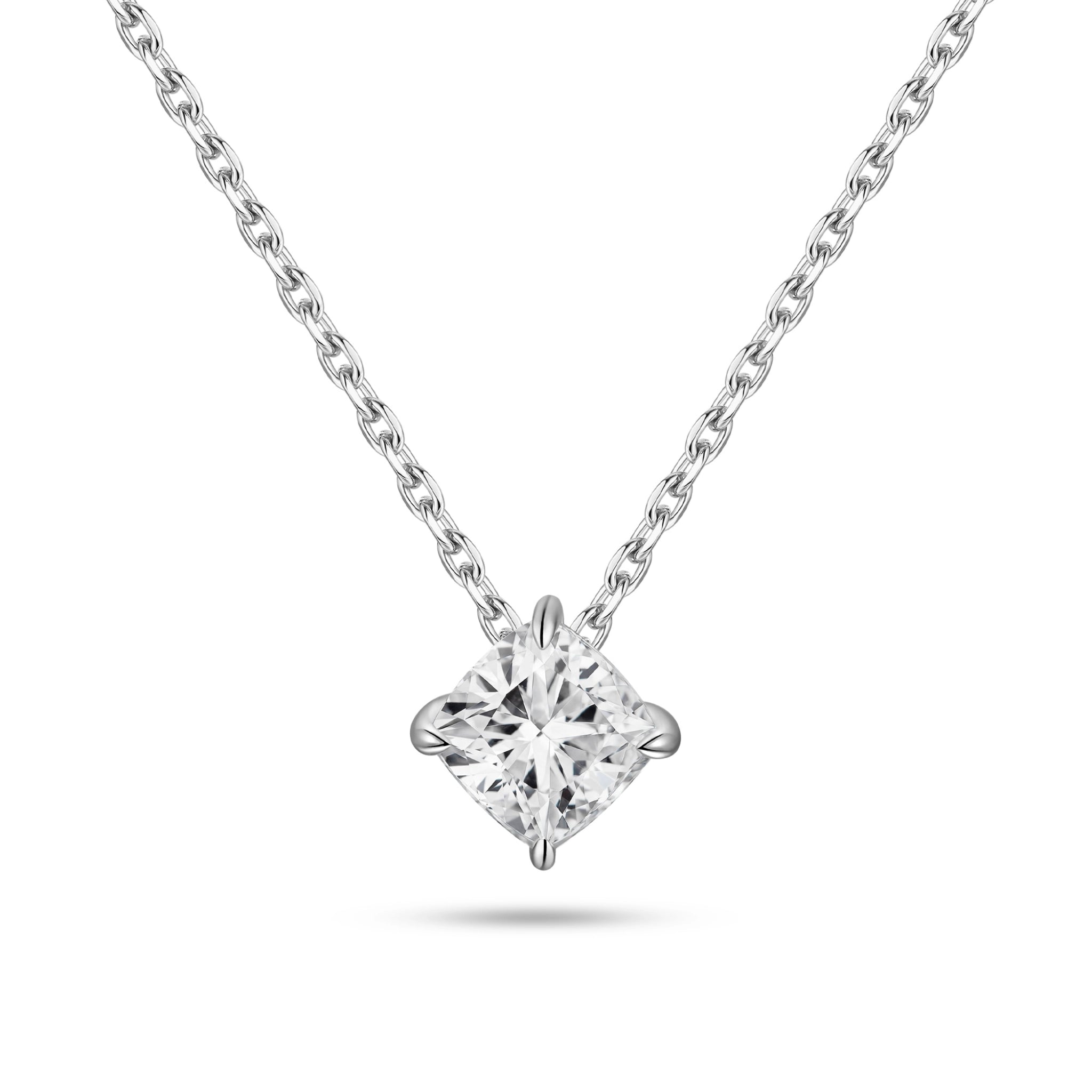 Front view of the J'ENCHANTE ONE cushion-cut diamond solitaire necklace. Suspended on a white gold chain, the brilliant cushion diamond is uniquely kite-set (compass set) to create a striking geometric silhouette. The refined single-stone design allows light to flow naturally, emitting a quiet yet confident brilliance.