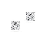 Front view of the J'ENCHANTE ONE cushion-cut diamond stud earrings in white gold. The minimalist design features a brilliant cushion-cut diamond on each ear. The soft, rounded corners of the cushion cut offer a pure vision of form, light, and balance for timeless everyday elegance.