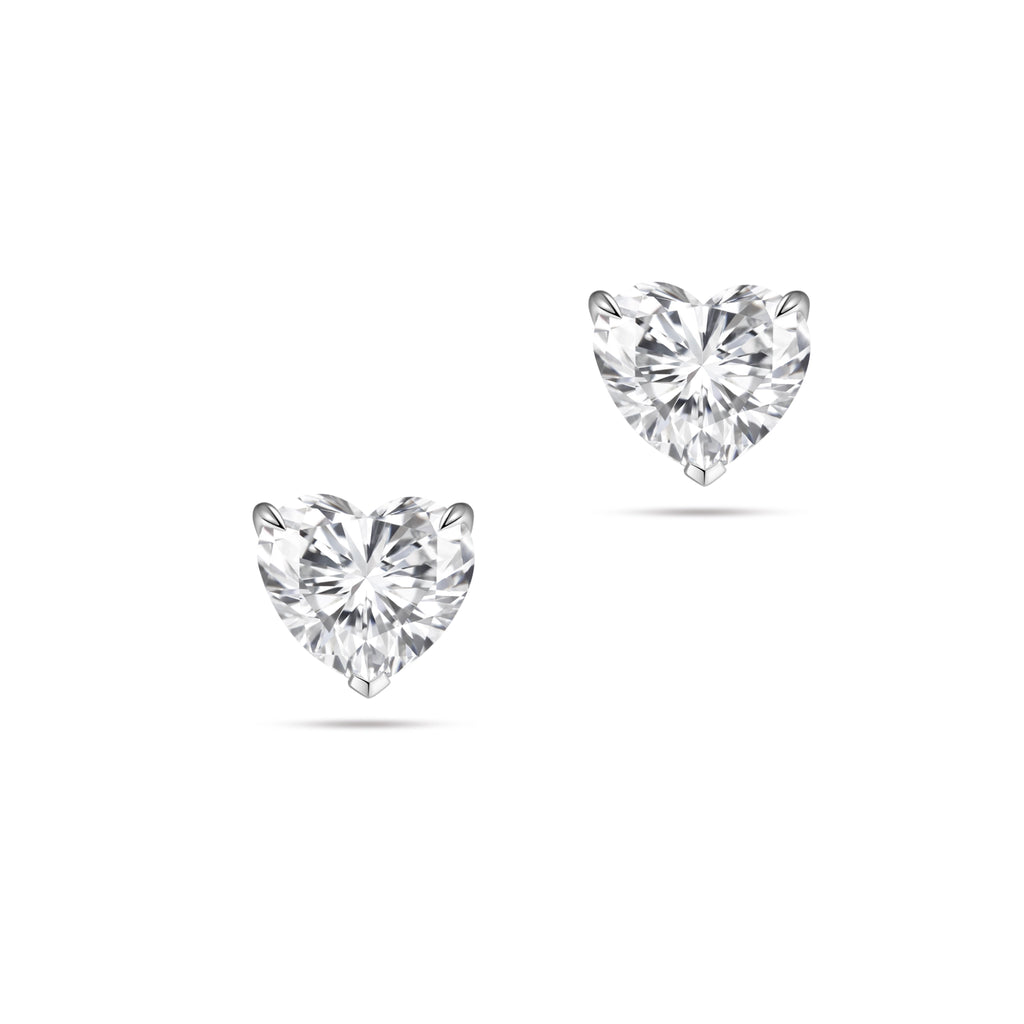 Front view of the J'ENCHANTE ONE heart-cut diamond stud earrings in white gold. The minimalist design features a brilliant heart-shaped center stone on each ear, beautifully highlighting its romantic silhouette and pure, distinctive brilliance.