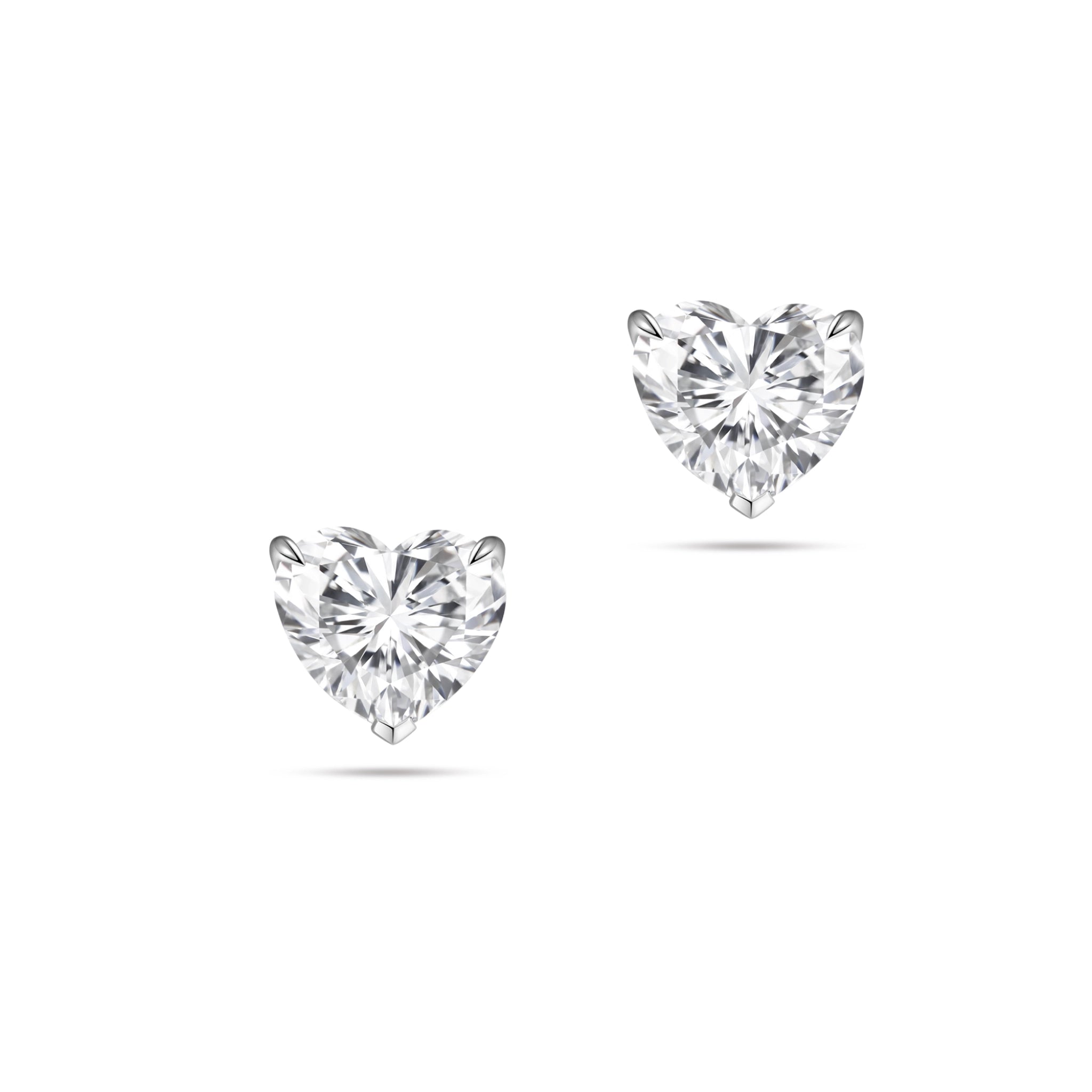 Front view of the J'ENCHANTE ONE heart-cut diamond stud earrings in white gold. The minimalist design features a brilliant heart-shaped center stone on each ear, beautifully highlighting its romantic silhouette and pure, distinctive brilliance.