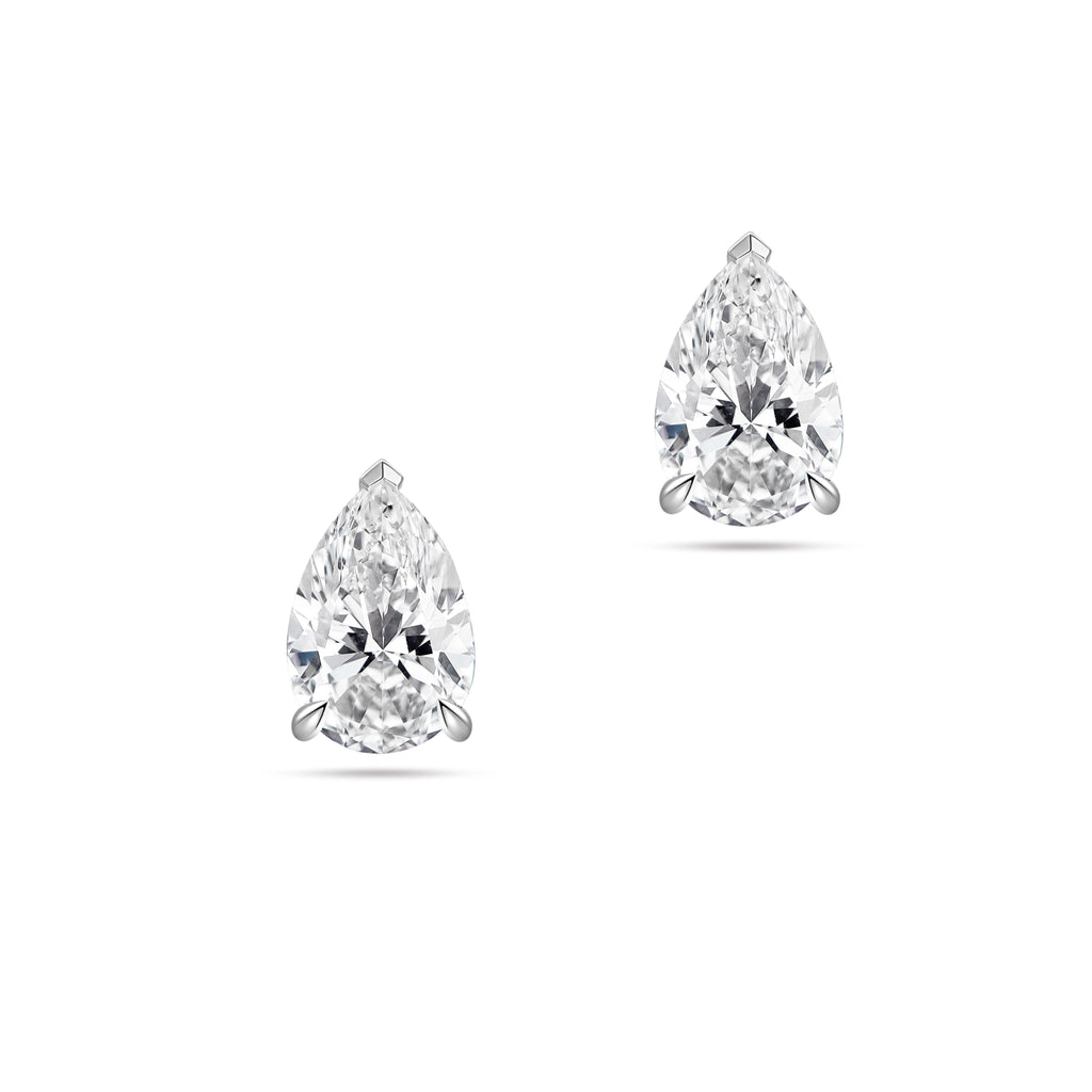 Front view of the J'ENCHANTE ONE pear-cut diamond stud earrings in white gold. Featuring a brilliant pear-shaped focal stone on each ear, the minimalist design perfectly balances soft, graceful curves with refined, precise definition for a clean and intentional statement.