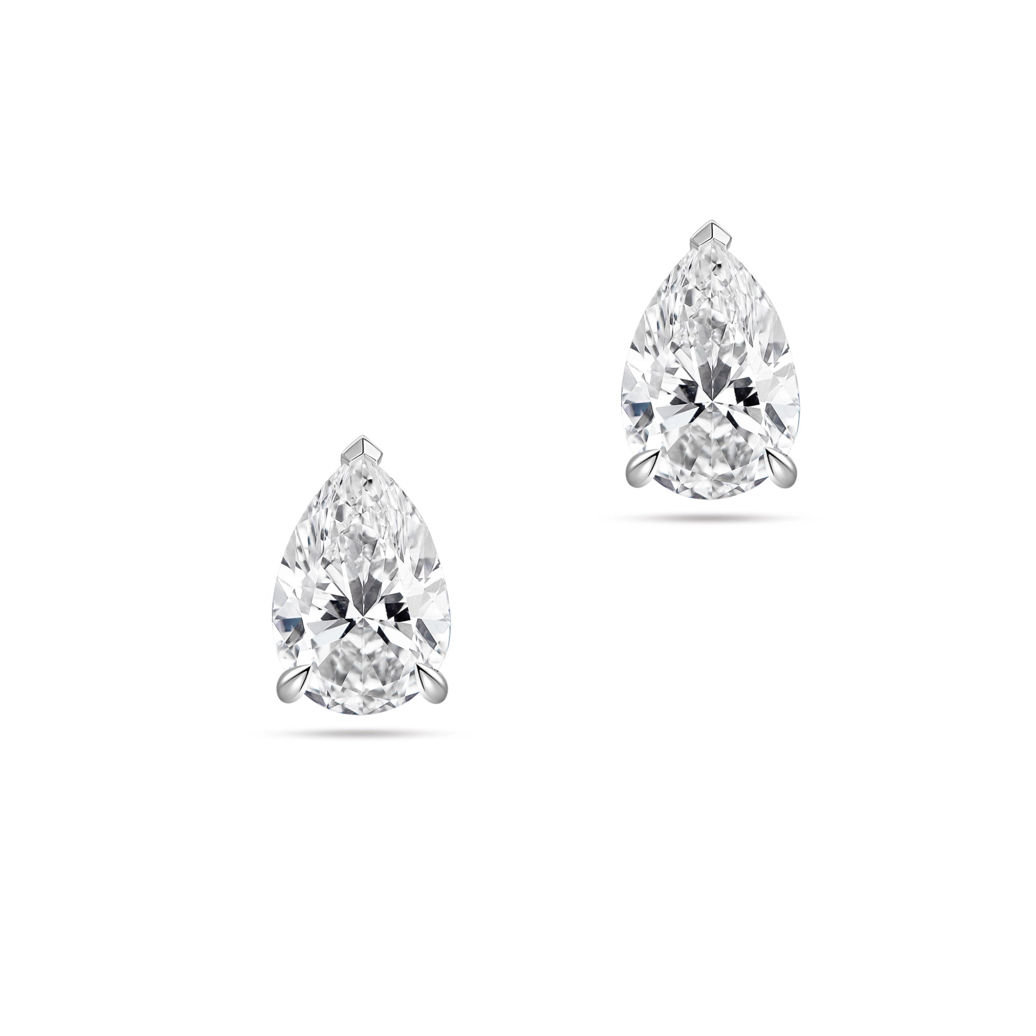 Front view of the J'ENCHANTE ONE pear-cut diamond stud earrings in white gold. Featuring a brilliant pear-shaped focal stone on each ear, the minimalist design perfectly balances soft, graceful curves with refined, precise definition for a clean and intentional statement.