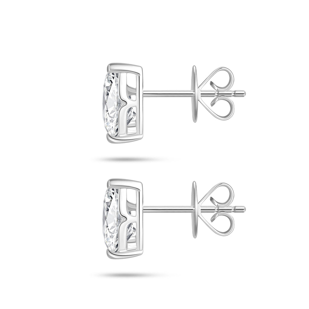 Side profile view of the J'ENCHANTE ONE pear diamond stud earrings, highlighting the signature J-setting and secure earring backs. The refined architectural curve supports and lifts the stone from the side, allowing light to pass through freely to dramatically enhance clarity and brilliance.