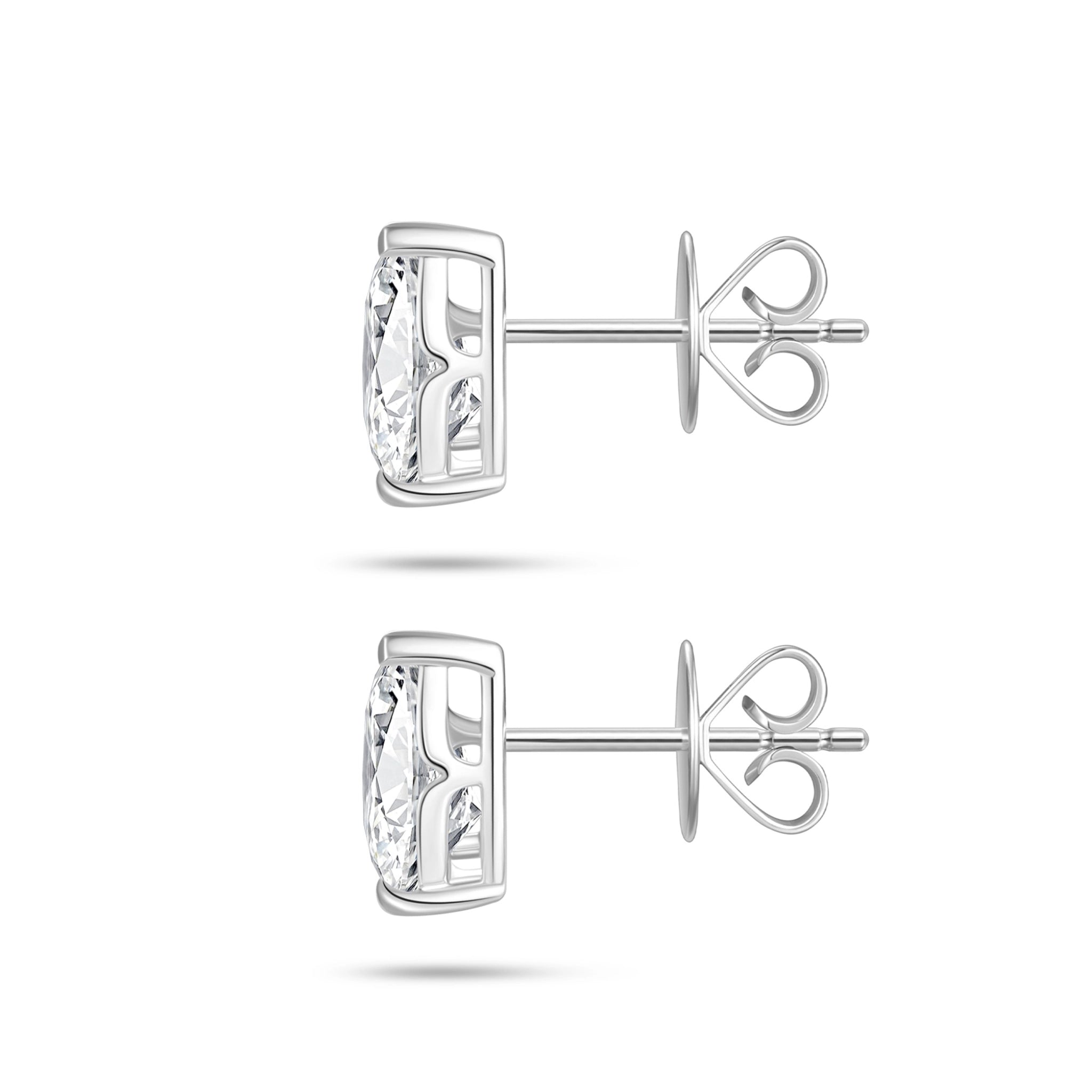 Side profile view of the J'ENCHANTE ONE pear diamond stud earrings, highlighting the signature J-setting and secure earring backs. The refined architectural curve supports and lifts the stone from the side, allowing light to pass through freely to dramatically enhance clarity and brilliance.