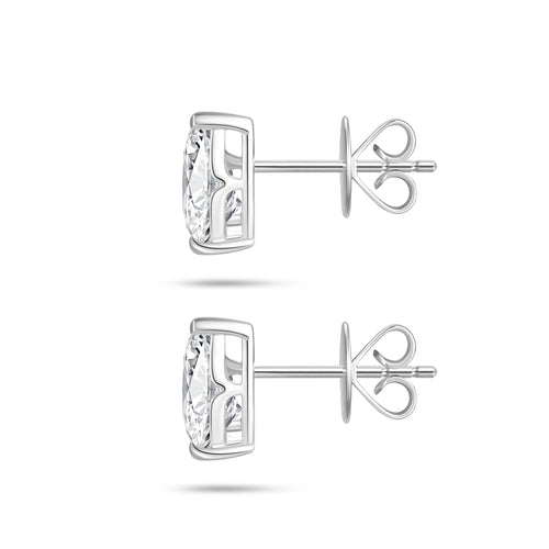 Side profile view of the J'ENCHANTE ONE pear diamond stud earrings, highlighting the signature J-setting and secure earring backs. The refined architectural curve supports and lifts the stone from the side, allowing light to pass through freely to dramatically enhance clarity and brilliance.