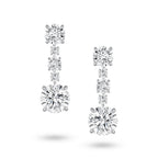 Front view of the J'ENCHANTE The Radiant Line diamond earrings in 18K white gold. Defined by a pure vertical composition, a precise sequence of graduating round brilliant diamonds unfolds into two commanding 3.0-carat bottom anchor stones (10 diamonds totaling approx. 9.08 carats). This flawless alignment creates a continuous, luminous flow of radiance for an elegant and effortless statement.
