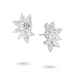 Angled view of the J'ENCHANTE The Solaris Bloom statement diamond earrings. The image highlights the 18K white gold setting and secure earring posts. This perspective reveals the striking three-dimensional depth and the intricate interplay of round, pear, and marquise-cut diamonds. This expertly arranged mixed-cut cluster enhances directional light, ensuring outward brilliance and clarity from every possible angle.
